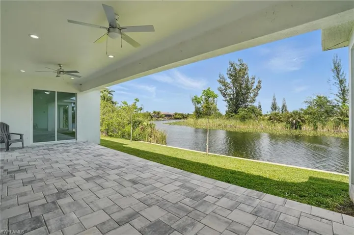 View of patio with a water view and ceiling fan
