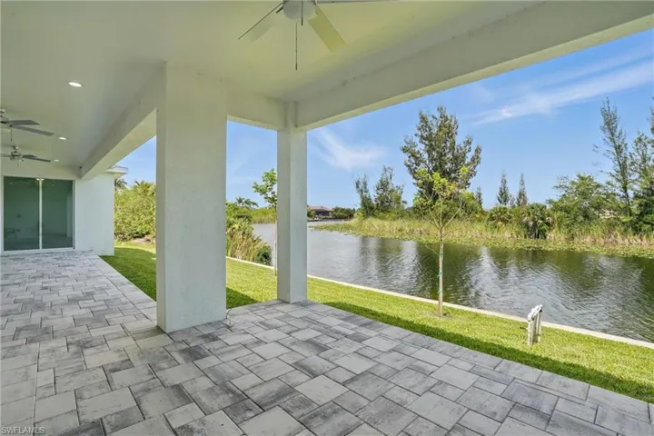 View of patio / terrace with ceiling fan and a water view