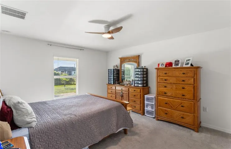 Carpeted bedroom with a ceiling fan