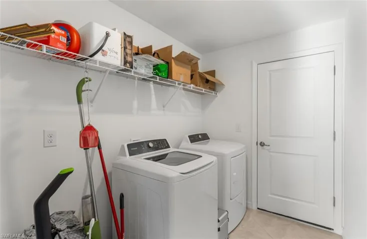 Washroom featuring light tile patterned flooring and separate washer and dryer