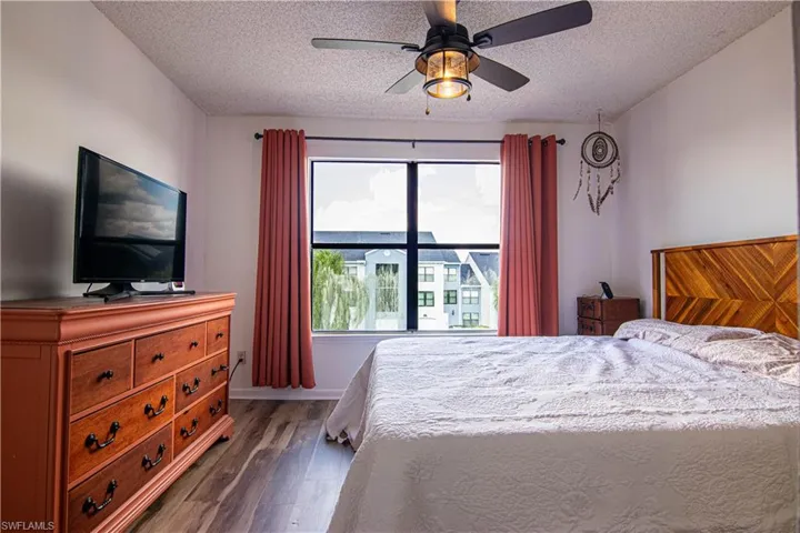Bedroom featuring dark wood-type flooring, a ceiling fan, and a textured ceiling