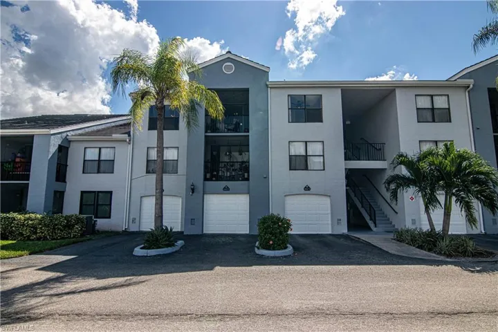 View of apartment building / complex with driveway and an attached garage