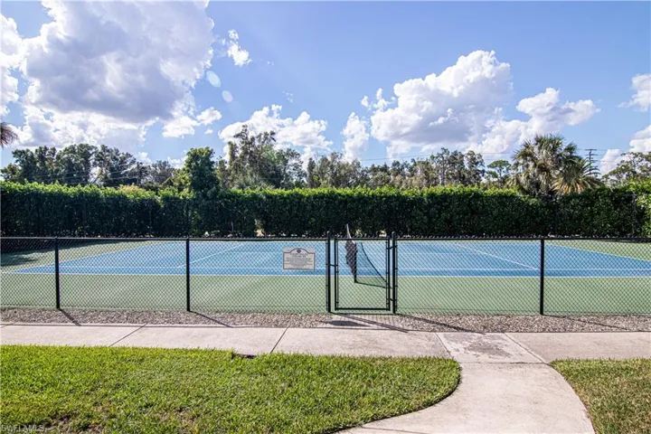 View of tennis court with a gate