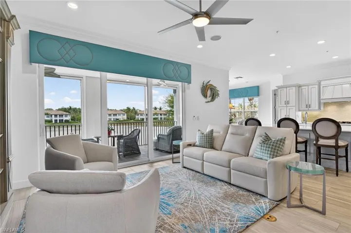 Living area featuring ornamental molding, ceiling fan, recessed LED lighting, light wood-style tile floors, water view