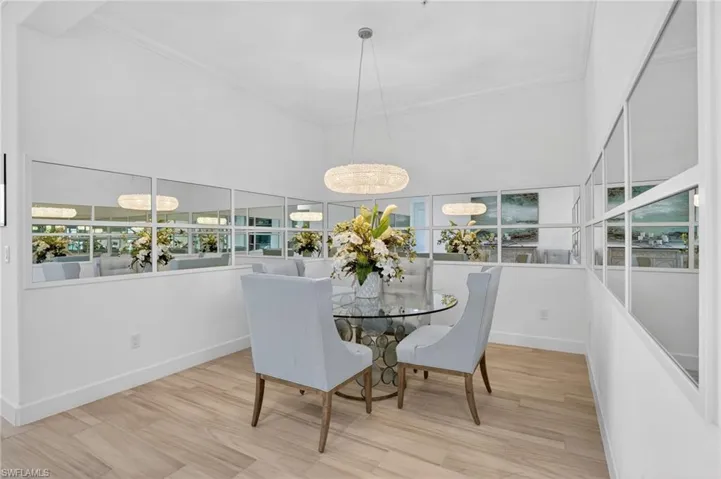 Dining room with light wood-style tile flooring, a high ceiling, and ornamental molding