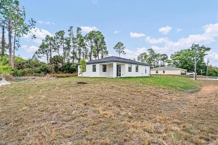 View of front of home featuring stucco siding and a front lawn