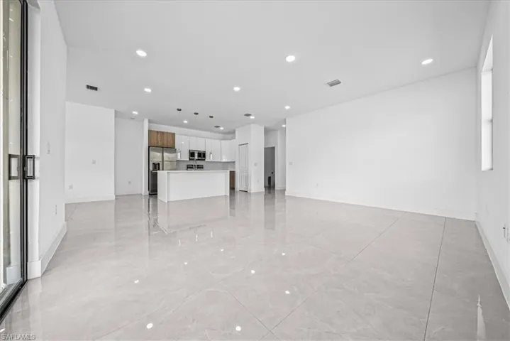 Unfurnished living room featuring recessed lighting and light marble finish floors