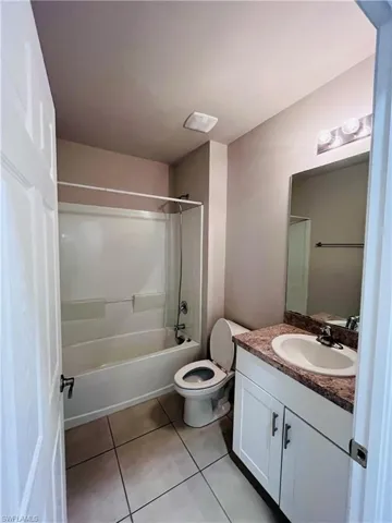 Full bath featuring vanity, bathtub / shower combination, and light tile patterned floors
