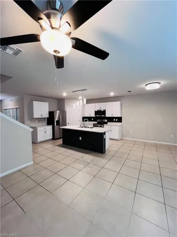 Kitchen featuring white cabinets, light countertops, light tile patterned floors, and recessed lighting
