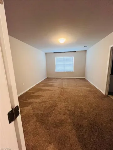 Carpeted spare room with baseboards