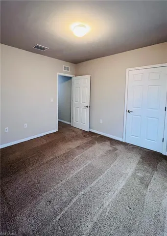 Unfurnished bedroom with carpet and baseboards