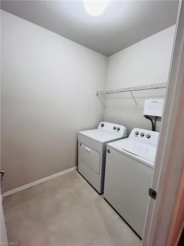 Laundry area featuring baseboards and washer and clothes dryer