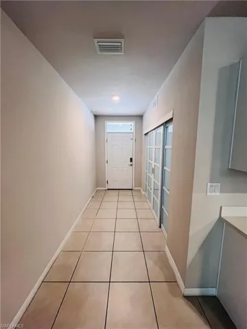 Corridor with baseboards and light tile patterned flooring