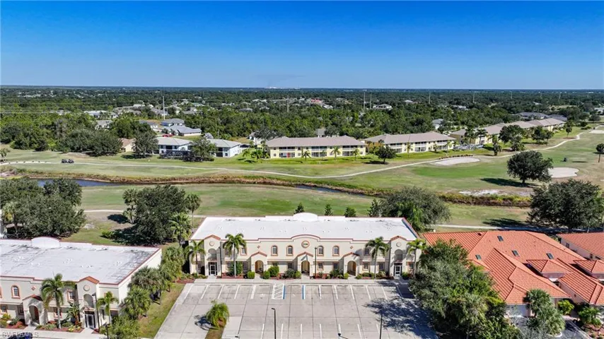 Aerial view of residential area with a golf course and a nearby body of water
