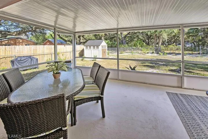Expansive lanai featuring large yard, fence and wooded area