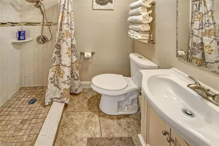 Full bathroom with tiled shower, toilet
