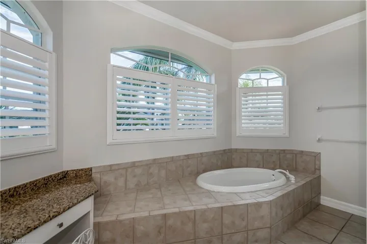 M-Bathroom with vanity, tiled bath, tile patterned floors, and ornamental molding