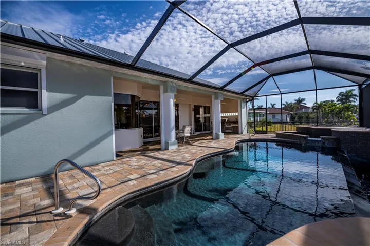 View of pool featuring a lanai, a patio, and an in ground hot tub