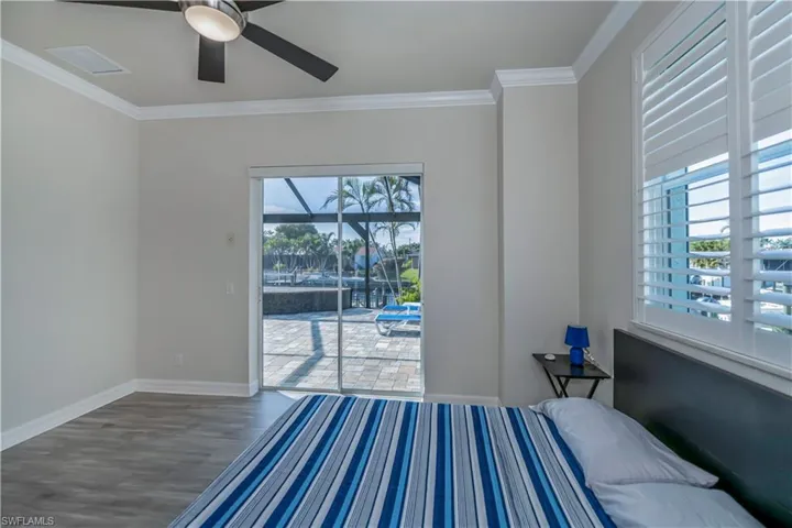 Bedroom featuring hardwood / wood-style flooring, ceiling fan, and crown molding