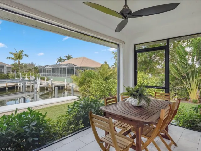 Sunroom with a water view, ceiling fan, and outdoor dining space