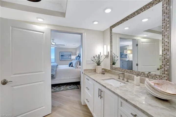 Ensuite bathroom with connected bathroom, ceiling fan, vanity, recessed lighting, and wood finished floors