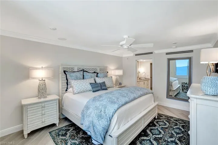 Bedroom featuring crown molding, baseboards, ensuite bathroom, and a ceiling fan