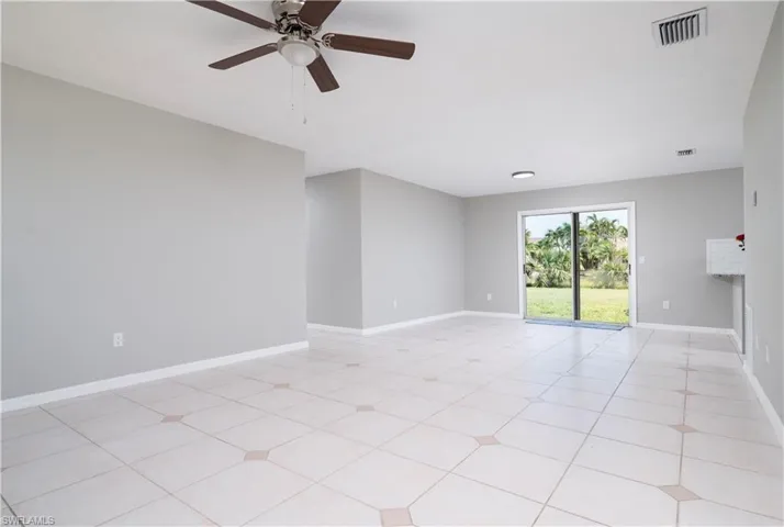 Empty room featuring a ceiling fan, visible vents, and baseboards