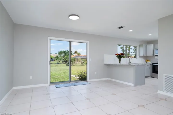 Unfurnished room featuring visible vents, plenty of natural light, and baseboards