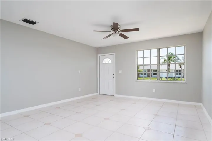 Unfurnished room with baseboards, visible vents, and ceiling fan