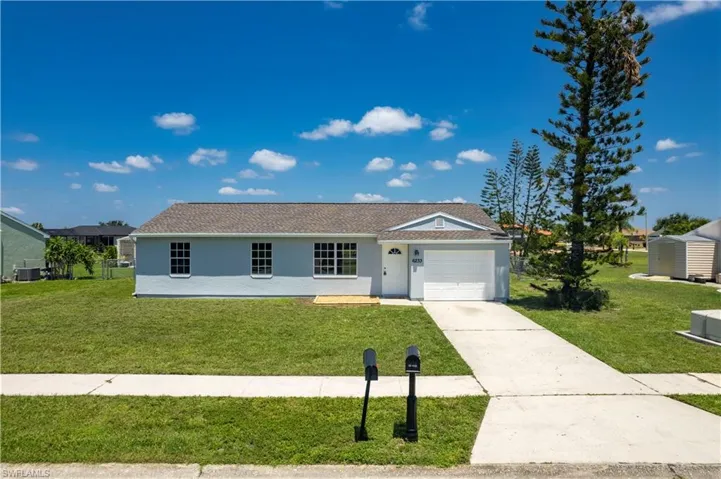 Ranch-style home featuring concrete driveway, a front lawn, central air condition unit, and stucco siding