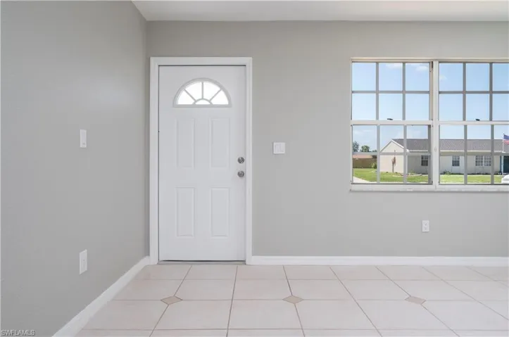 Foyer entrance featuring baseboards and light tile patterned floors