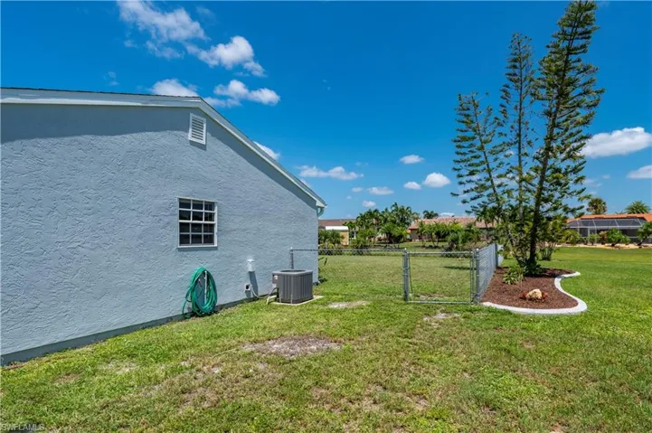 View of yard featuring central air condition unit and fence