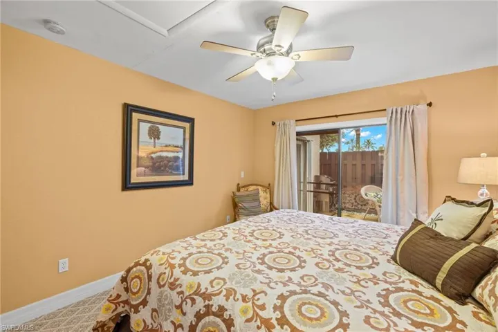 Carpeted bedroom featuring ceiling fan