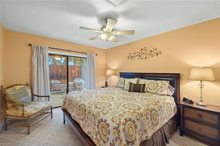 the downstairs bedroom with carpet flooring, access to outside, and ceiling fan