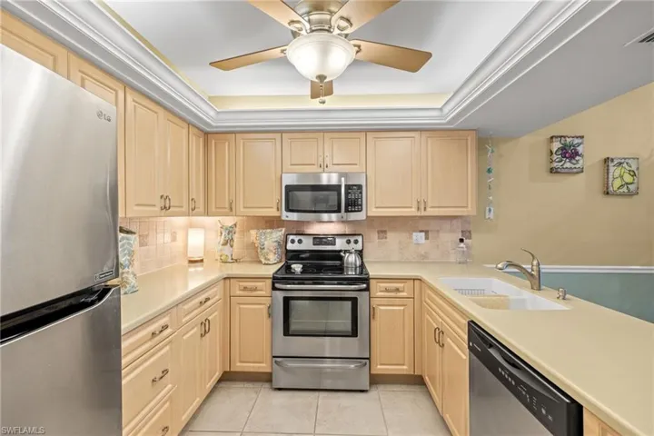 Kitchen with tray ceiling and additional ceiling lighting.