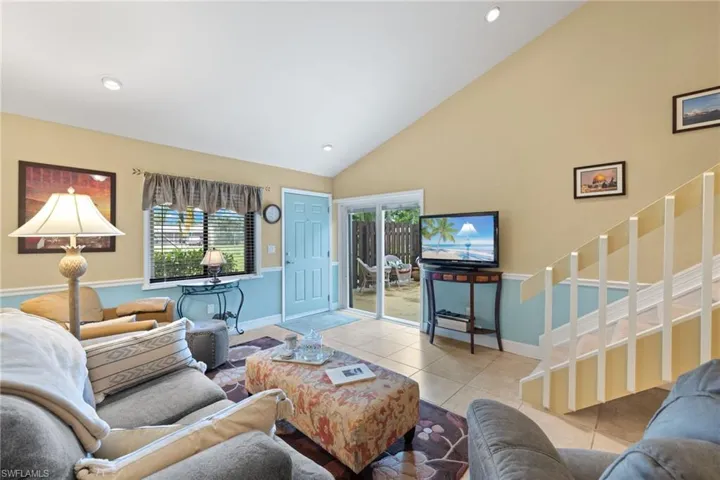 Tiled living room with plenty of natural light and opens to the fenced patio.