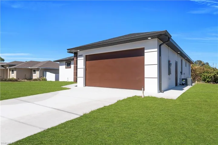 View of home's exterior with a yard, stucco siding, and concrete driveway