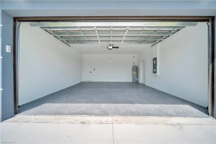 Garage featuring electric water heater and electric panel