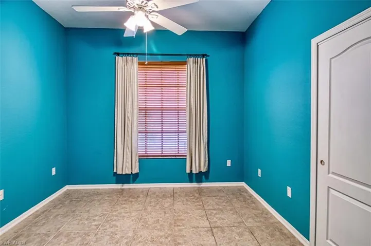 Empty room with ceiling fan and baseboards