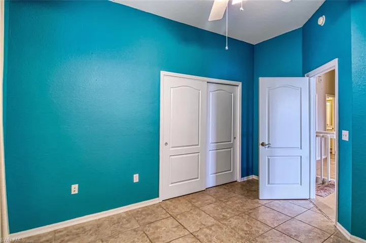 Unfurnished bedroom with a closet, ceiling fan, and a textured wall