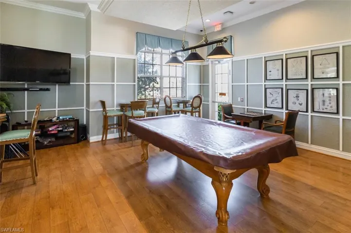 Game room with pool table, a textured ceiling, crown molding, and a decorative wall