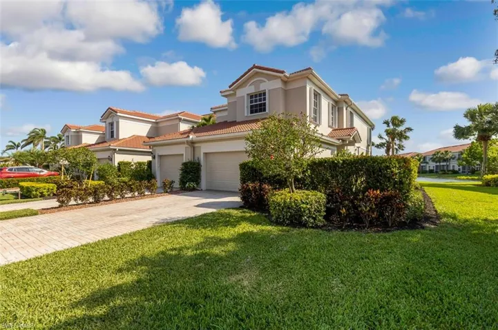 Mediterranean / spanish home featuring driveway, a tile roof, stucco siding, and a front yard