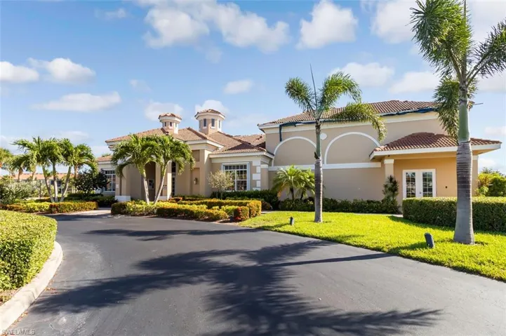 View of front of home featuring stucco siding, a front lawn, and a tile roof