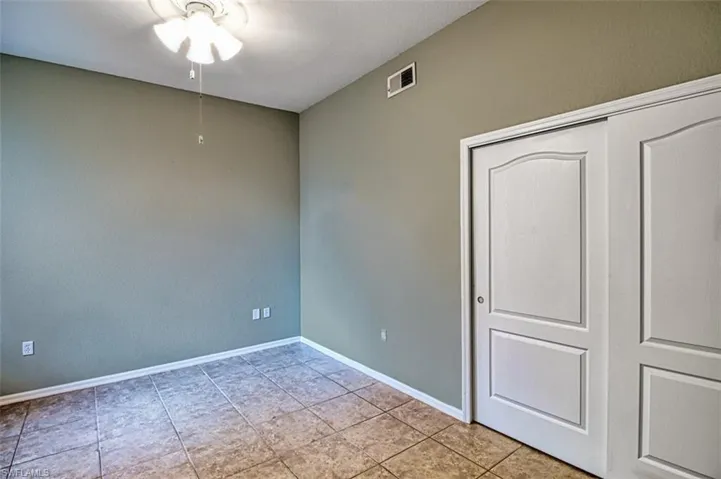 Unfurnished bedroom with ceiling fan and a closet