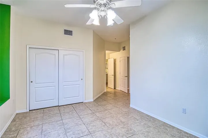 Unfurnished bedroom featuring ceiling fan, a closet, and light tile patterned floors