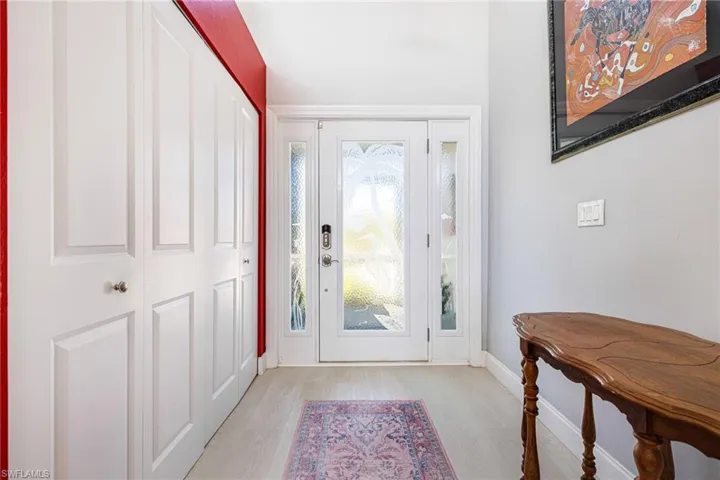 Foyer with light wood-style floors and baseboards