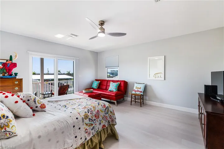 Bedroom with light wood-style flooring, access to outside, and a ceiling fan