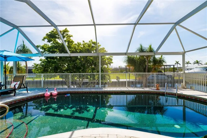 Swimming pool featuring a patio area and glass enclosure