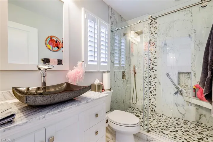 Full bathroom with a marble finish shower and vanity