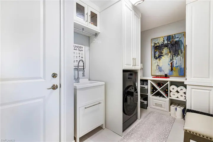 Laundry room with cabinet space, washer / clothes dryer, and light tile patterned floors